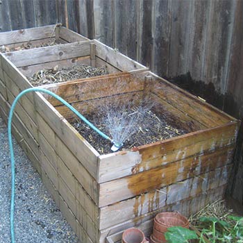 soil being watered in wooden boxes